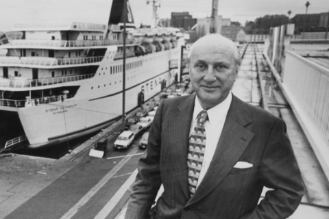 Black and white photo of a man in suit and tie in front of a Stena ferry