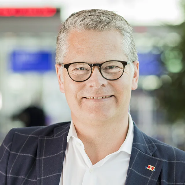 Portrait of a smiling man wearing glasses and a suit