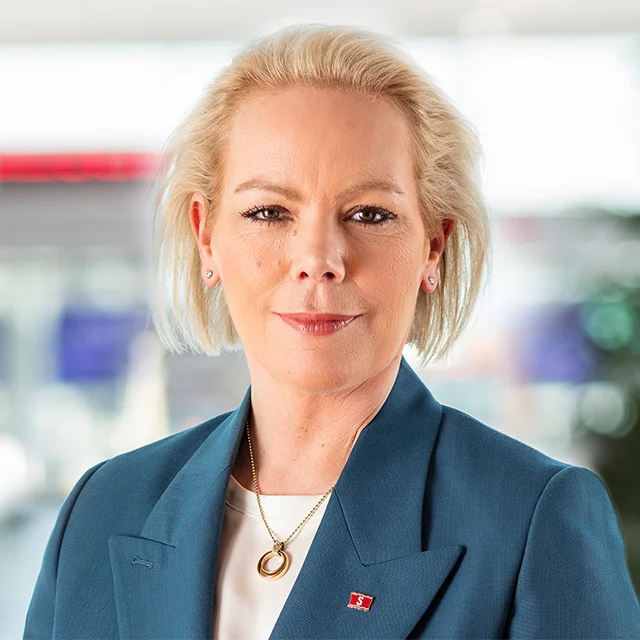 Blonde, smiling woman wearing a suit