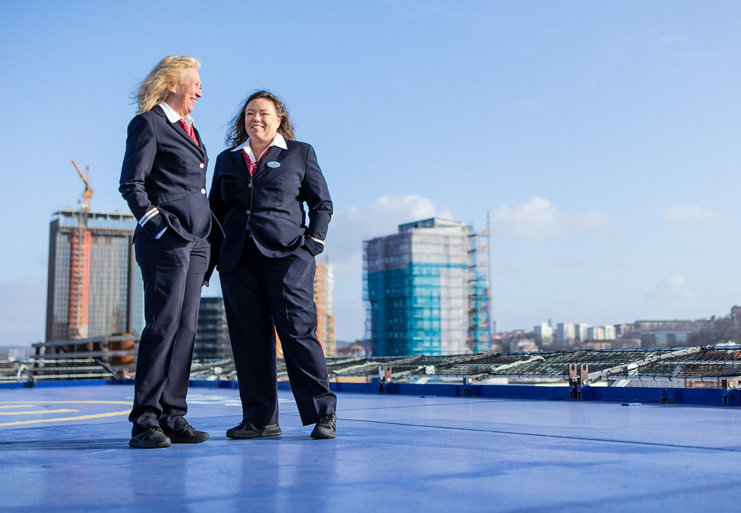 Two women with a city skyline background